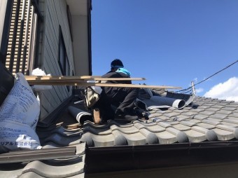 瓦桟を撤去していく職人を下から撮影