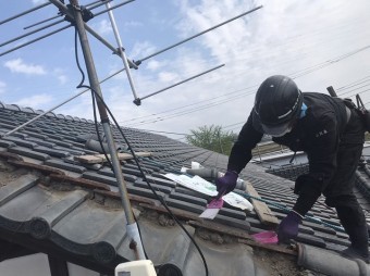 中腰で風切丸の土台を清掃する職人