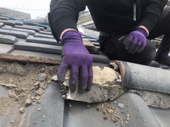 風切丸の土台にある漆喰を撤去する職人