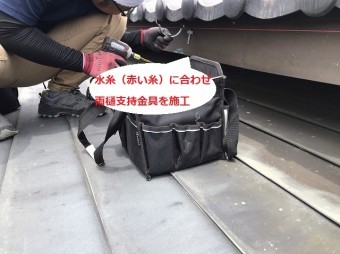 水糸に合わせ雨樋支持金具を取り付ける職人