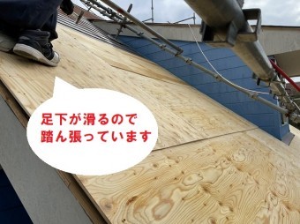 滑らないように踏ん張っている屋根職人