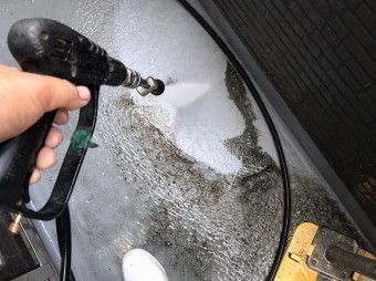 高圧洗浄をベランダの汚れに噴射する職人