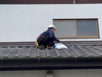 既存の葺き止め漆喰を剥がす作業をしている職人