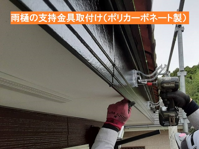 ポリカーボネート製の雨樋支持金具を取り付ける職人
