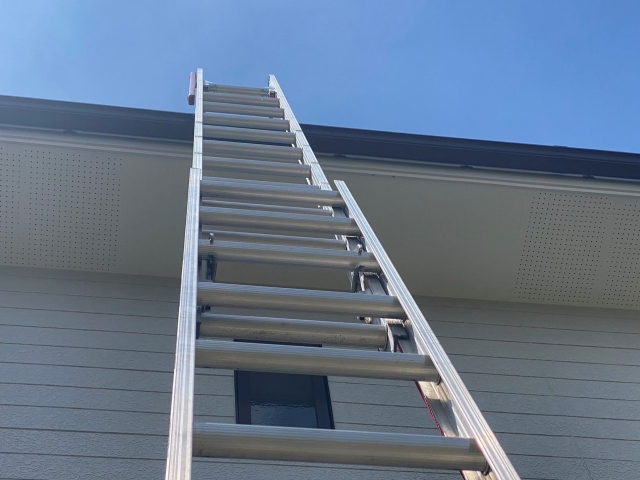 屋根調査のため、二連梯子を伸ばして軒先に架ける