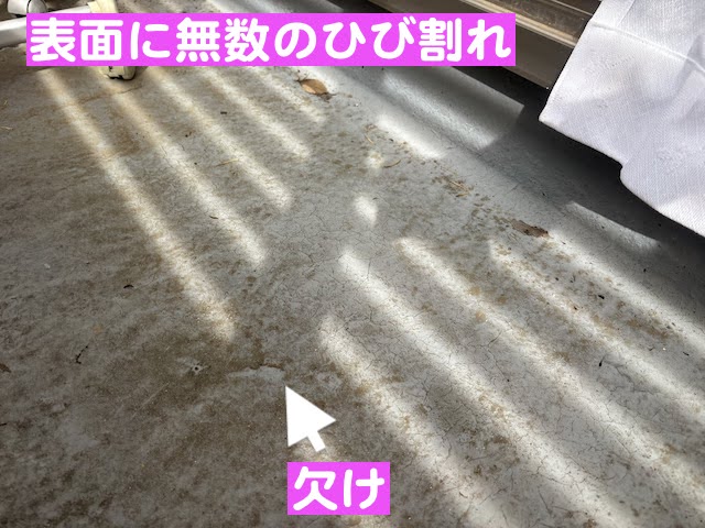 無数の小さなひび割れが広がり表層が欠けたベランダの床面