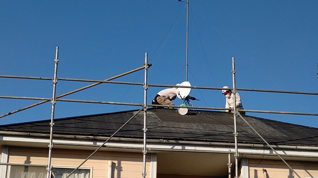 屋根修理作業中の二名のスタッフを地上から撮影