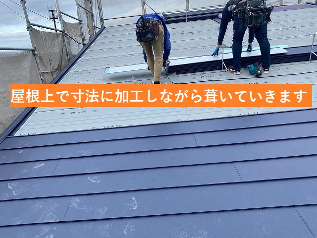 屋根上で採寸通りに屋根材を加工していく職人