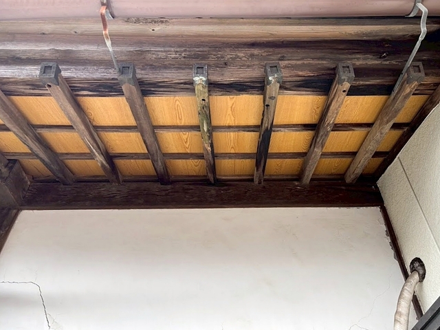 谷板金を交換した後化粧ベニヤで修復された玄関先の軒天