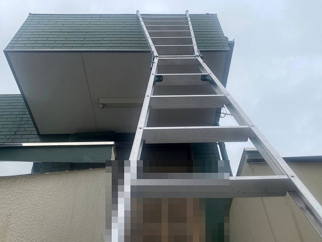 長尺二連梯子を使用して三階建てビルの屋根を確認