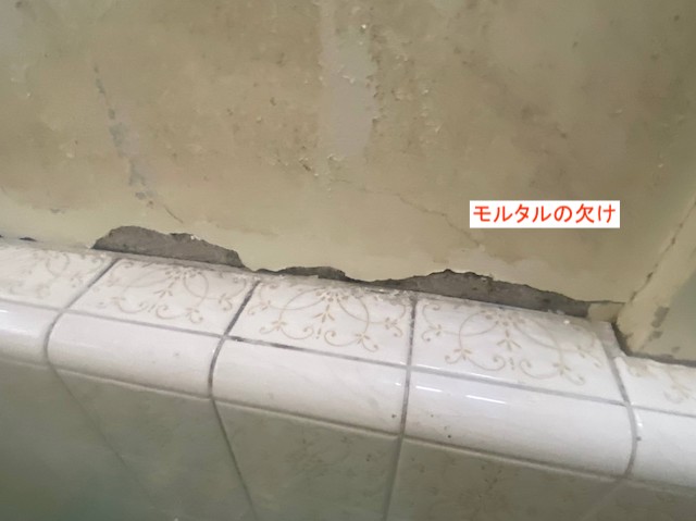 壁のモルタルが欠けた浴室