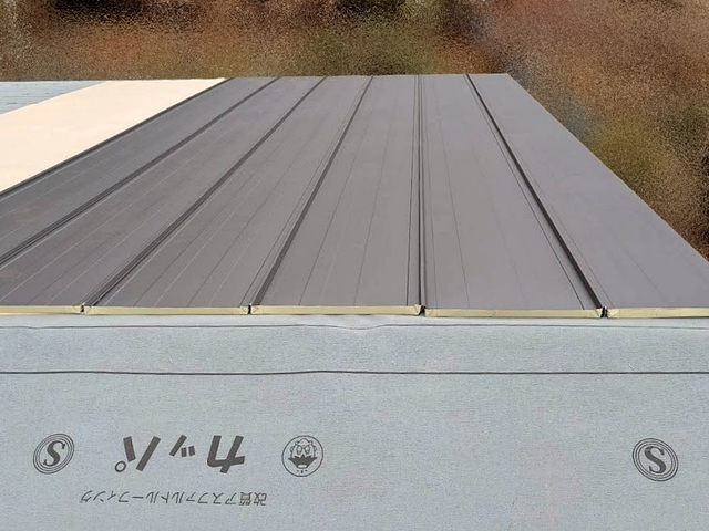 一枚ずつ位置を確認して立平葺きのガルバリウム鋼板を設置
