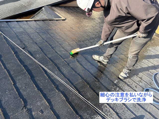 デッキブラシで屋根を洗浄する職人