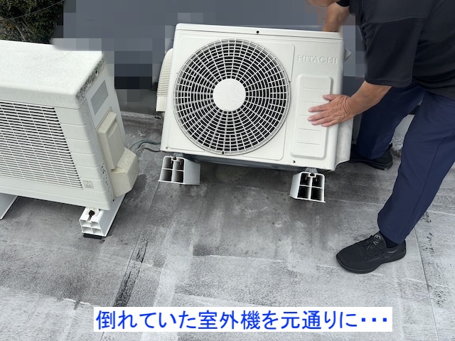 倒れていたエアコンの室外機を起こすスタッフ