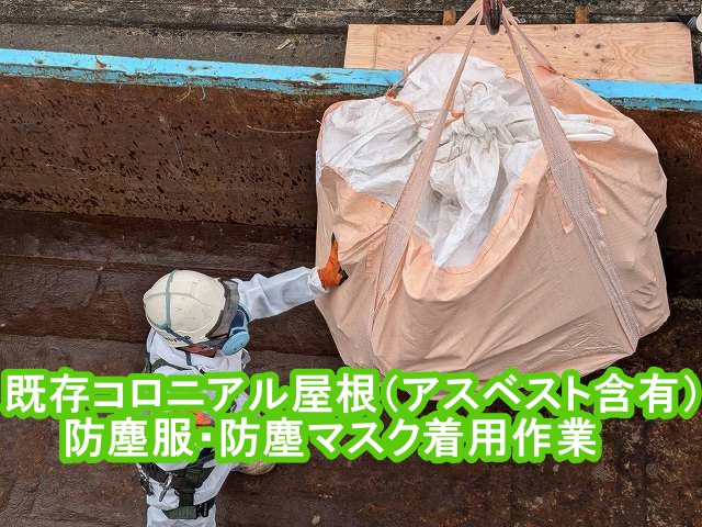 防塵服と防塵マスク着用でアスベスト含有屋根材をフレコンバックで降ろす作業員