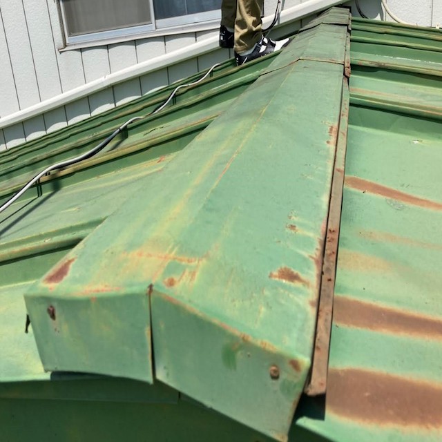 端から見た、錆びついた緑色の金属屋根