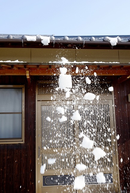 玄関先に屋根から雪が落ちるイメージ画像