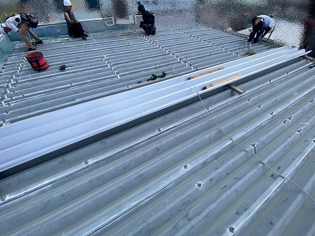 4人体制で折板屋根にタイトフレームを取り付け