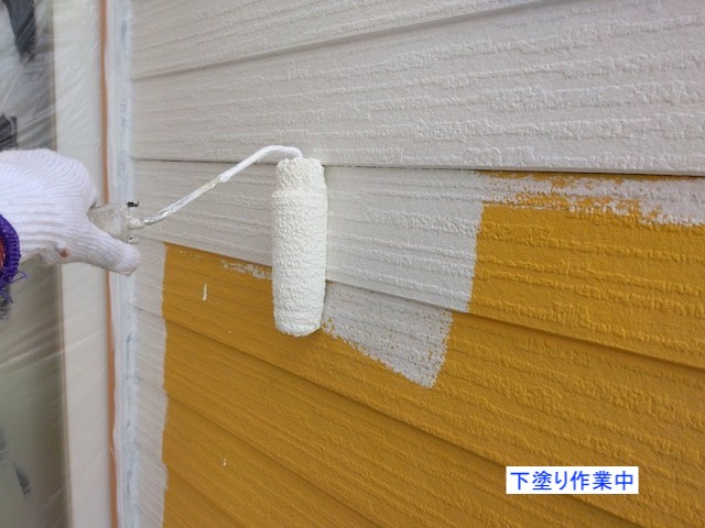 黄色い外壁に下塗りを塗布