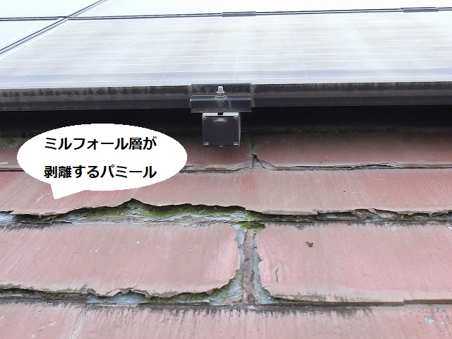 赤いパミール屋根材の表面が剥がれ基材が露出している