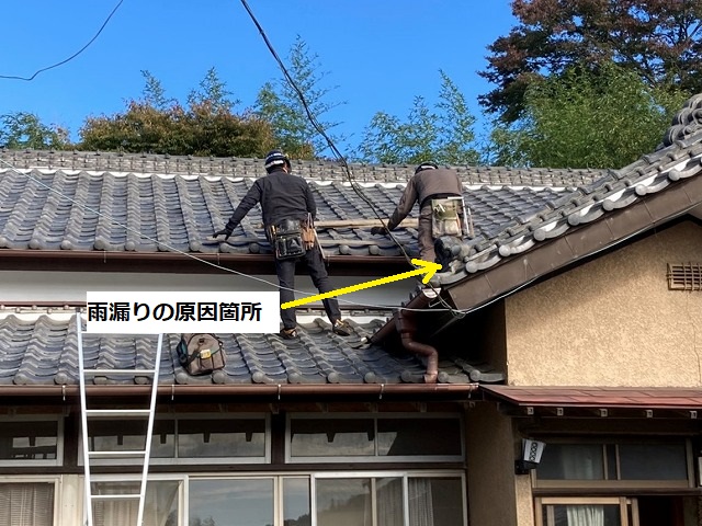 二名の職人が屋根に登り屋根修理の準備をする