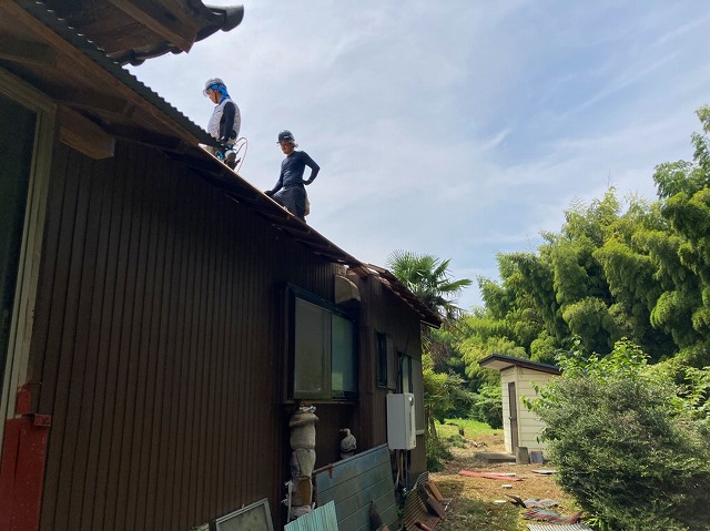 波トタン屋根の解体を行なう職人