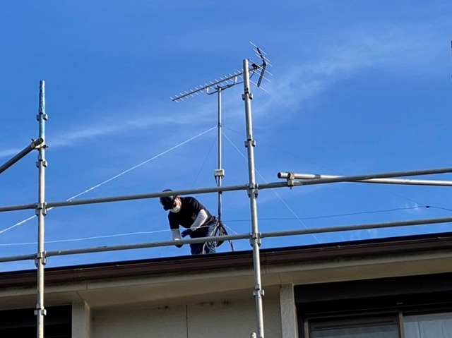 屋根上で作業する職人を地上から撮影
