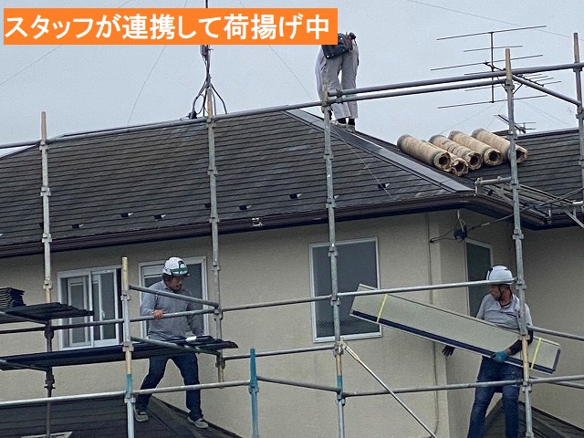 スタッフが連携し、屋根上に資材を揚げる