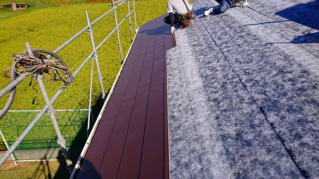 パミール屋根に粘着式防水シートを施工中
