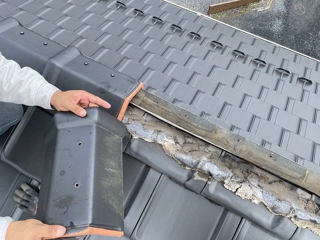 段違い屋根の棟瓦を取り外すスタッフ