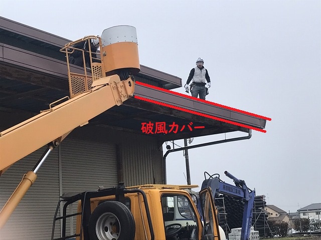 高所作業車で折板屋根に登る作業員