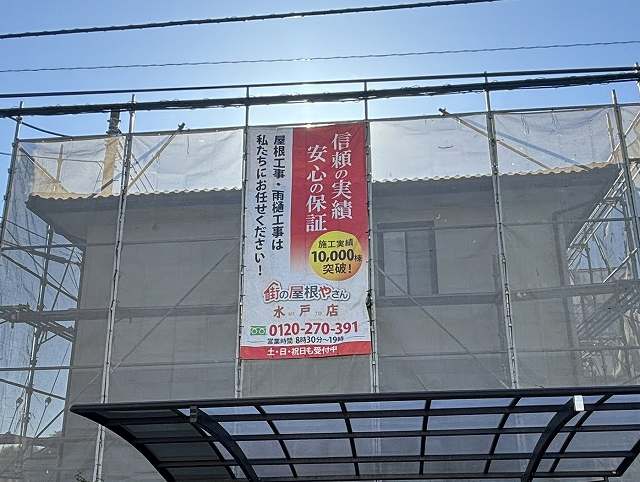 常陸太田市の屋根葺き替え現場に足場を設置し街の屋根やさん水戸店のイメージシートを掲げる